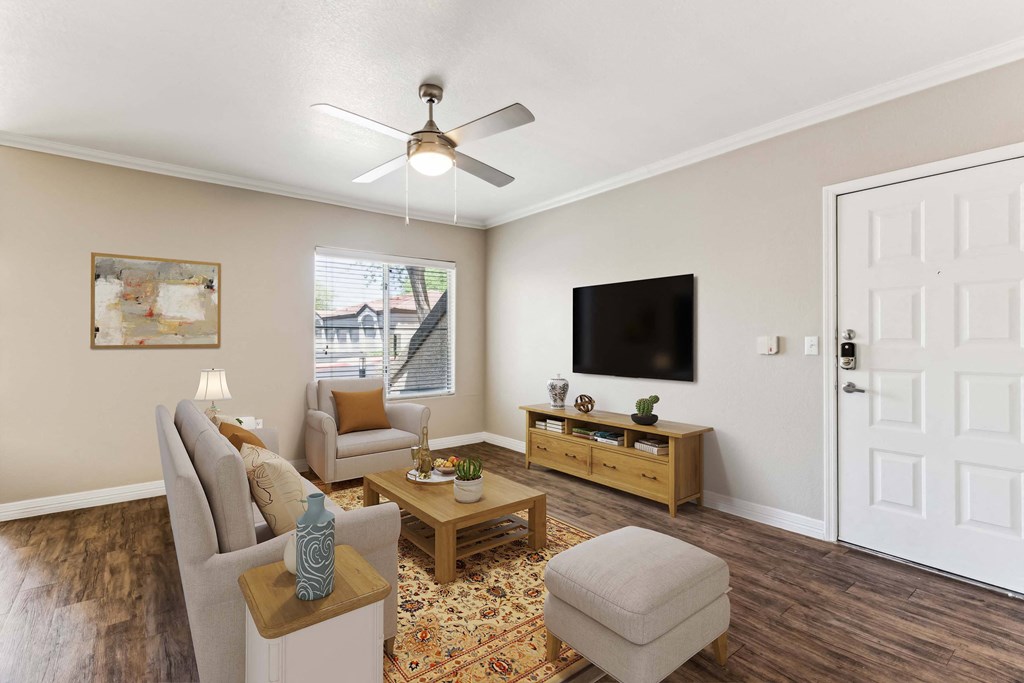 an open living room with a ceiling fan and a tv at Altezza High Desert, Albuquerque